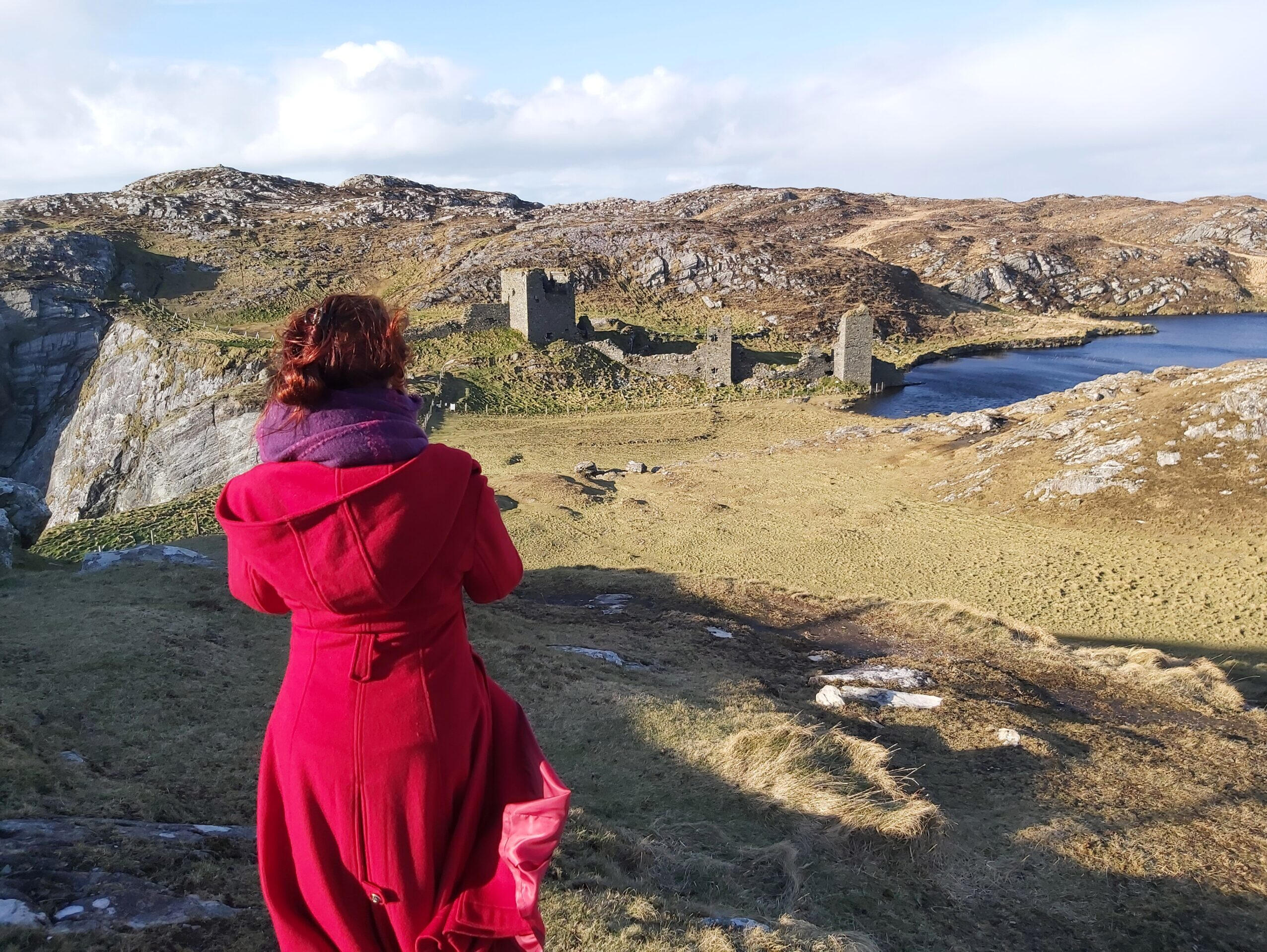 A woman gazing out over a castle ruin on an Irish cliff, contemplating the feeling that I have everything but I feel empty